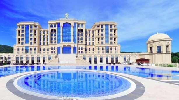 A large hotel with a central courtyard pool, multiple balconies, and a symmetrical facade. - Quba Palace Hotel & Golf Resort (Quba)