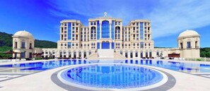 A large hotel with a central courtyard pool, multiple balconies, and a symmetrical facade. - Quba Palace Hotel & Golf Resort (Quba)