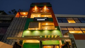 A multi-story building with a sign reading 'TOWNHOUSE OAK' and a company-serviced label. - Super Deluxe Room Hotel Ballian's (Prayagraj)