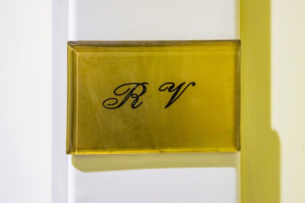 Ein rechteckiges Objekt mit einer reflektierenden Oberfläche und der Aufschrift 'R W' in Schreibschrift.