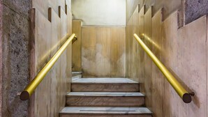 A staircase with marble steps and golden handrails, leading to an arched ceiling. - Luxury Toledo 22 (Naples)