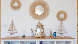 A wooden shelf with decorative items including two small sailboats, a lantern, and a mirror. - Holiday Home 'Lacaducee' with Balcony, Wi-Fi and Air Conditioning (Peujard)