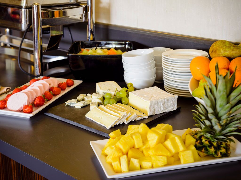 Ein Buffet mit verschiedenen Käsesorten, Früchten und einer Ananas.