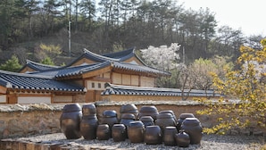 A traditional building with a tiled roof and stone walls, surrounded by large ceramic pots.