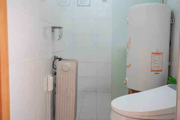A bathroom with a toilet, a radiator, and a water heater. - Cheongsong HANOK HOTEL ANN (Cheongsong)