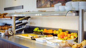 Un buffet proposant des fruits, des pâtisseries et une machine à café.