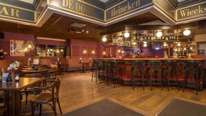A bar area with multiple stools and a bar counter, featuring brand names like DE DORBE, Heineken, and WIECKS.