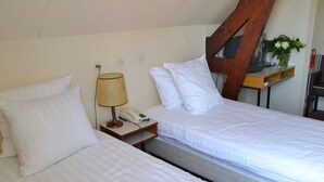 A hotel room with two single beds, a bedside lamp, a telephone, and a wooden headboard. - Short Drive to Beach! Free Breakfast and Parking, Close to Brielse Meer! (Brielle)