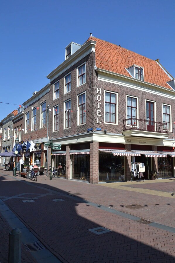 A hotel with a brick facade, multiple windows, and a sign reading 'HOTEL RESTAURANT DE ZALM'.