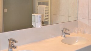 Une salle de bain avec deux lavabos, un miroir et un porte-serviettes.
