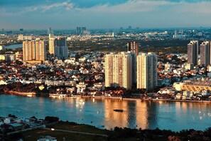 A cityscape with high-rise buildings, a river, and a densely populated area with residential and commercial structures. - 1 Bedroom Apartment for Rent at Vinhomes Central Park (Thành phố Hồ Chí Minh)