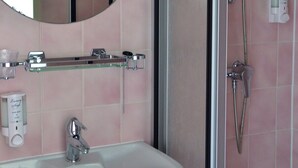 A bathroom with a sink, mirror, shower, and towel rack. - Relaxing Place with On-site Dining, Breakfast and Access to Town Walks! (Brielle)