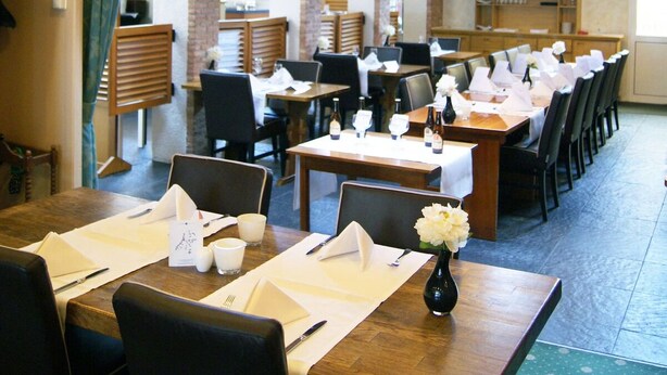 A restaurant with brick walls, wooden tables, and black chairs. - Relaxing Place with On-site Dining, Breakfast and Access to Town Walks! (Brielle)