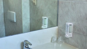 A bathroom with a white sink, a mirror, and a towel rack.