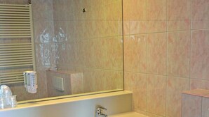Une salle de bain avec un lavabo, un miroir et des toilettes.