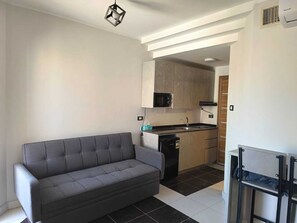 A compact living space with a sofa, kitchenette, and a small dining area. - Royal Beach Resort (Hurghada)