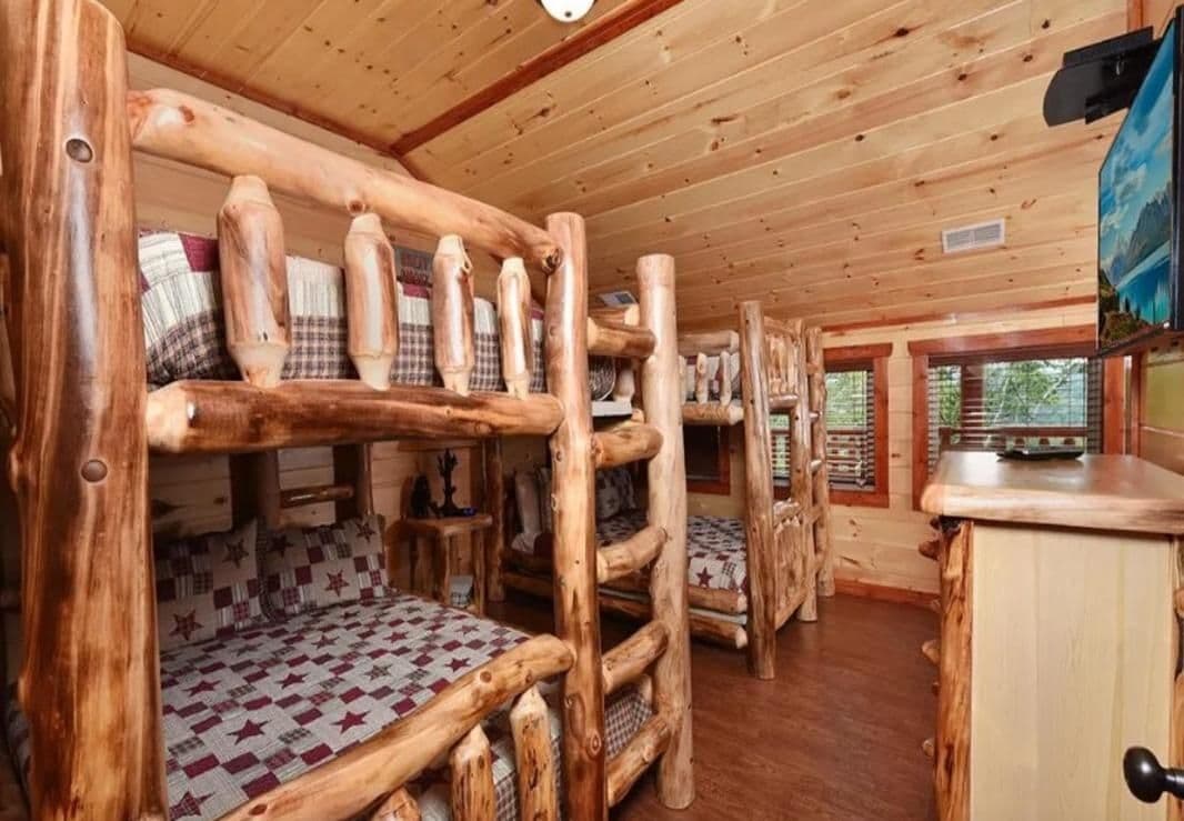L'intérieur d'une cabine avec des lits superposés, des murs en bois et un téléviseur.
