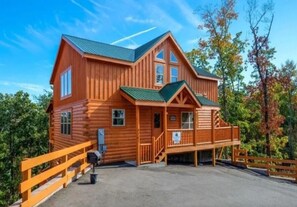 Eine große Holzhütte mit Veranda, mehreren Fenstern und einer überdachten Treppe.