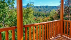 A wooden deck with a metal railing overlooking a forested valley. - Sherwood Love To See You Again 3 Bedroom Cabin (Pigeon Forge)