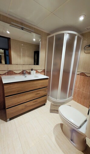 A modern bathroom with a wooden vanity, a shower enclosure, and a toilet. - Exclusive apartment in front of the sea parking included top location (Orpesa)