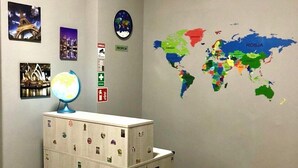 Una habitación con un mapa del mundo, un globo terráqueo y un escritorio con una lámpara.