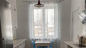 Una cocina moderna con una mesa de comedor, sillas y un refrigerador.