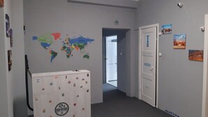 Ein Flur mit einer Weltkarte, einem Koffer und Türen, die mit Ländernamen beschriftet sind.