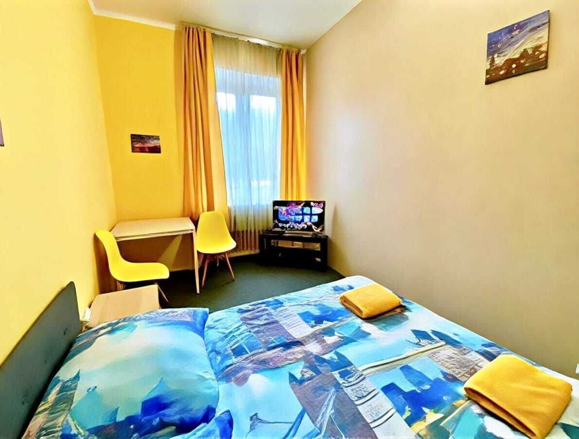 Une chambre d’hôtel avec un lit, un bureau, une chaise, une télévision et un tableau au mur.