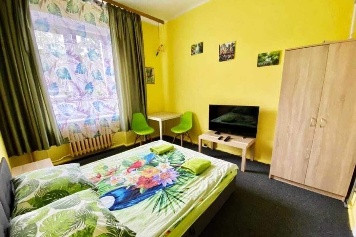 Une chambre d’hôtel équipée d’un lit, d’une télévision, d’un bureau et d’une armoire.