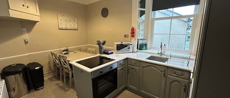 A kitchen with a built-in oven, a microwave, a sink, and a window with a view.