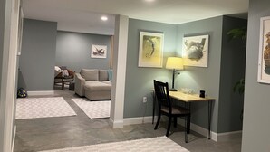 A living room with a sofa, a dining table with a chair, and artwork on the walls. - Eagles Nest in the village of Geneseo (Geneseo)