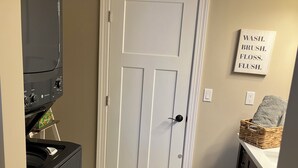 A kitchen with a microwave, oven, and a white door. There's a sign on the wall that says 'WASH. BRUSH. FLOSS. FLUSH.' - Eagles Nest in the village of Geneseo (Geneseo)