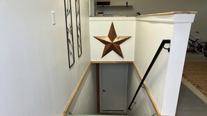 A narrow stairway with a star decoration on the wall, a door at the bottom, and a bicycle in the background. - Eagles Nest in the village of Geneseo (Geneseo)