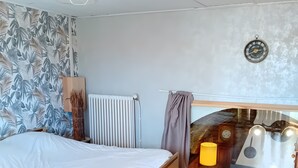 Une chambre avec un lit en bois, un radiateur, une horloge murale et une décoration murale de style rustique.