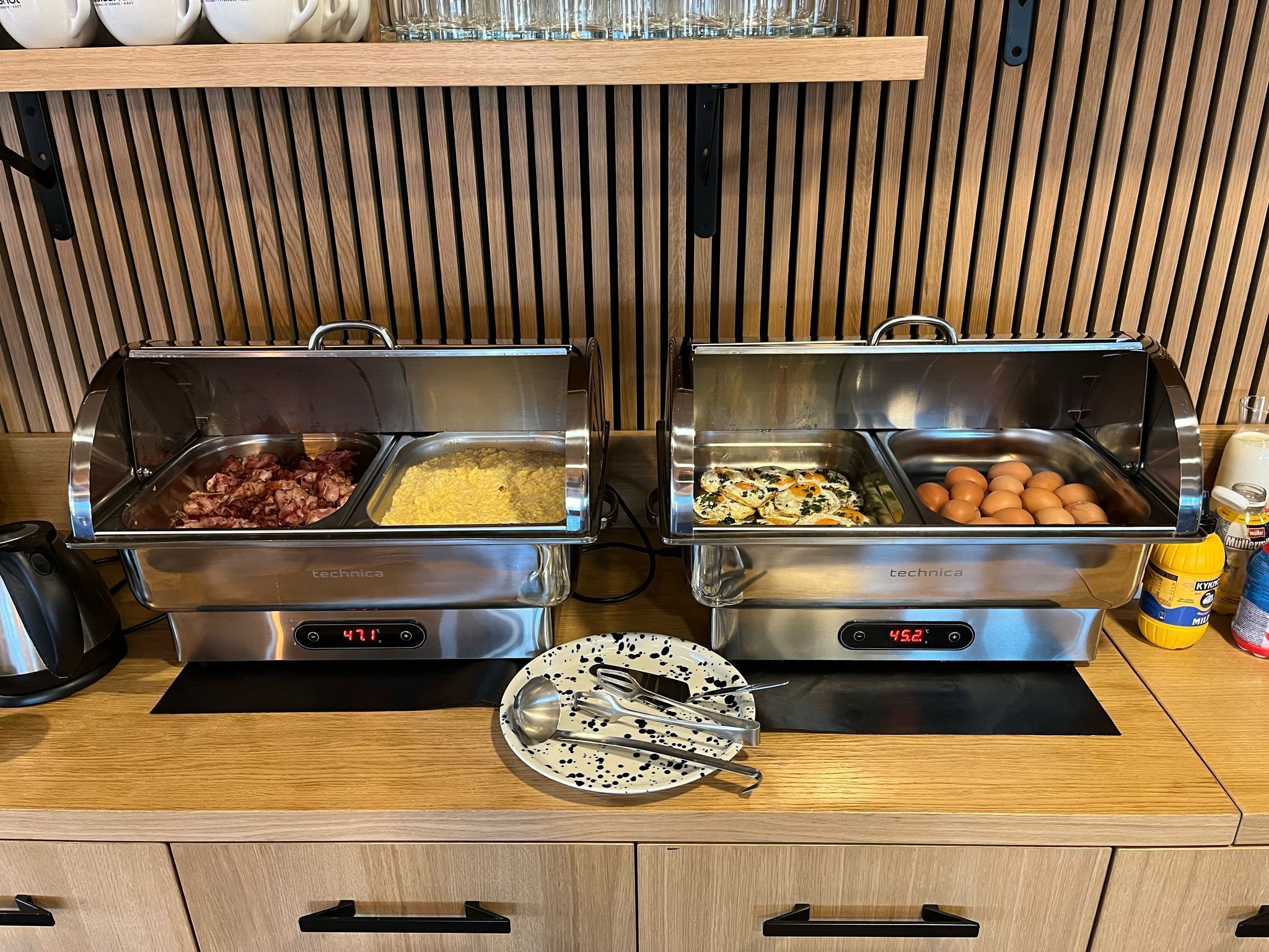 Un buffet était installé avec deux plats de service en acier inoxydable, dont l’un était étiqueté « technica » et maintenait une température de 47 °C, et l’autre, à 45,2 °C. Ces plats contenaient divers aliments.