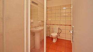 Un baño con inodoro, lavamanos y paredes con azulejos.