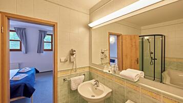 A hotel bathroom with a sink, mirror, and shower.