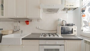Eine Küche mit Herd, Mikrowelle und Backofen.