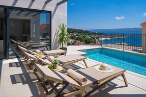 A modern outdoor pool area with sun loungers, a small pool, and a view of the sea. - NEW! Discover Villa Logos: Your Seaview Retreat in Croatia (Dugi Rat)