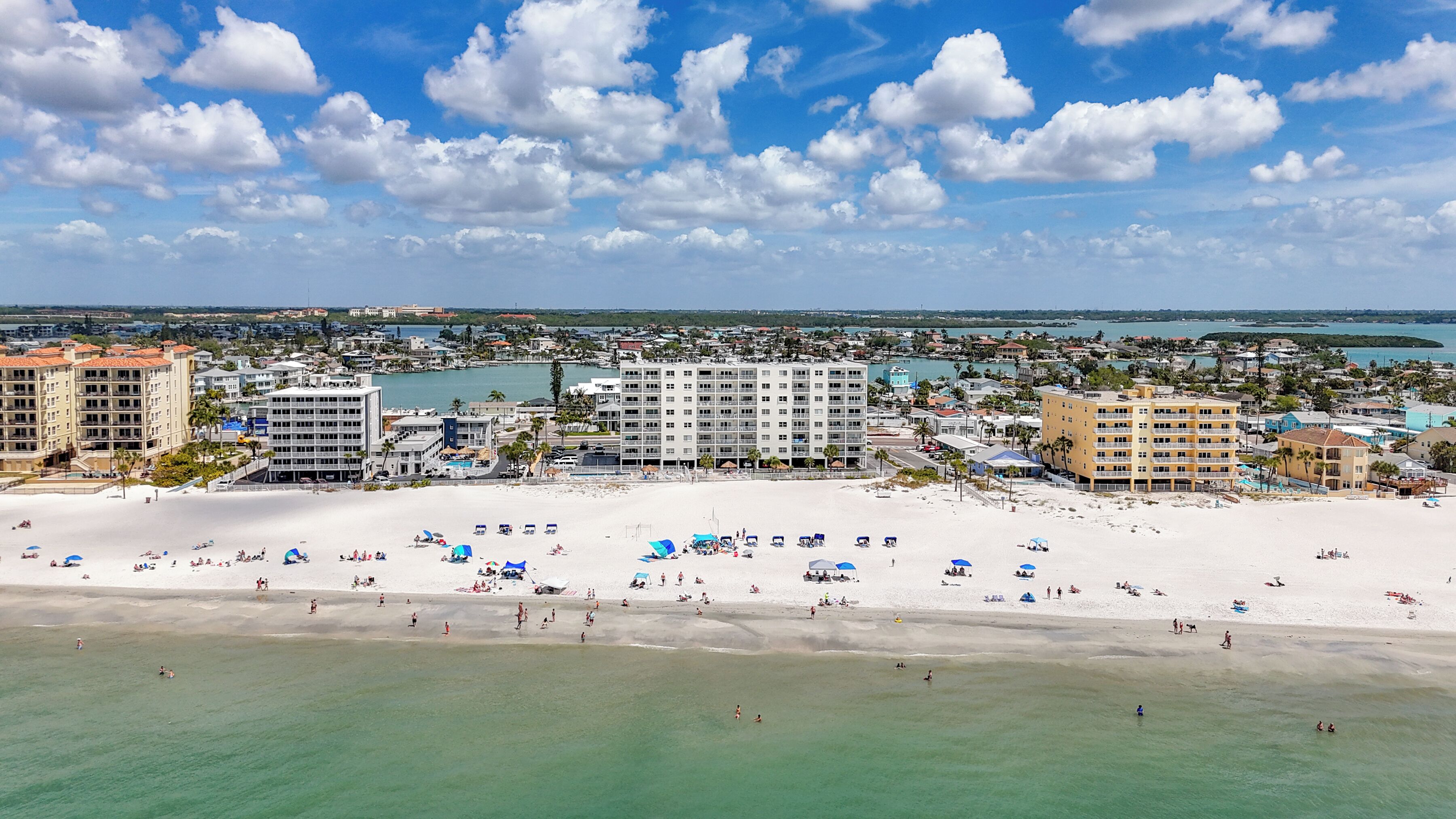 A coastal resort with beachfront accommodations, a sandy beach, and a marina.
