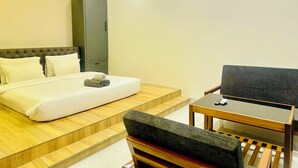 Une chambre à coucher comprenant un lit, un bureau, une chaise, une armoire et un ventilateur de plafond.