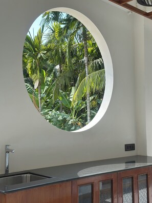 A circular window with a view of tropical foliage. - Welcome to Roys Villa Havelock. Relax, unwind, and enjoy your stay.
-happy stay (South Andaman)
