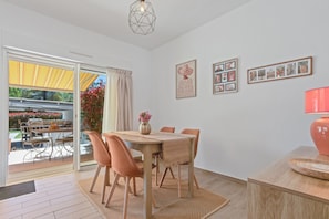 Un coin repas avec une table, des chaises et un vase de fleurs.