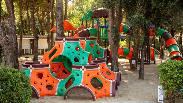 A playground with colorful play structures and trees. - Jesolo Family Resort (Jesolo)