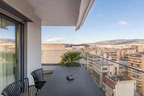 Ein Balkon mit Tisch, Stühlen und einer Topfpflanze.