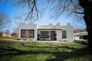 A modern two-story house with a white exterior, black trim, and a front porch.