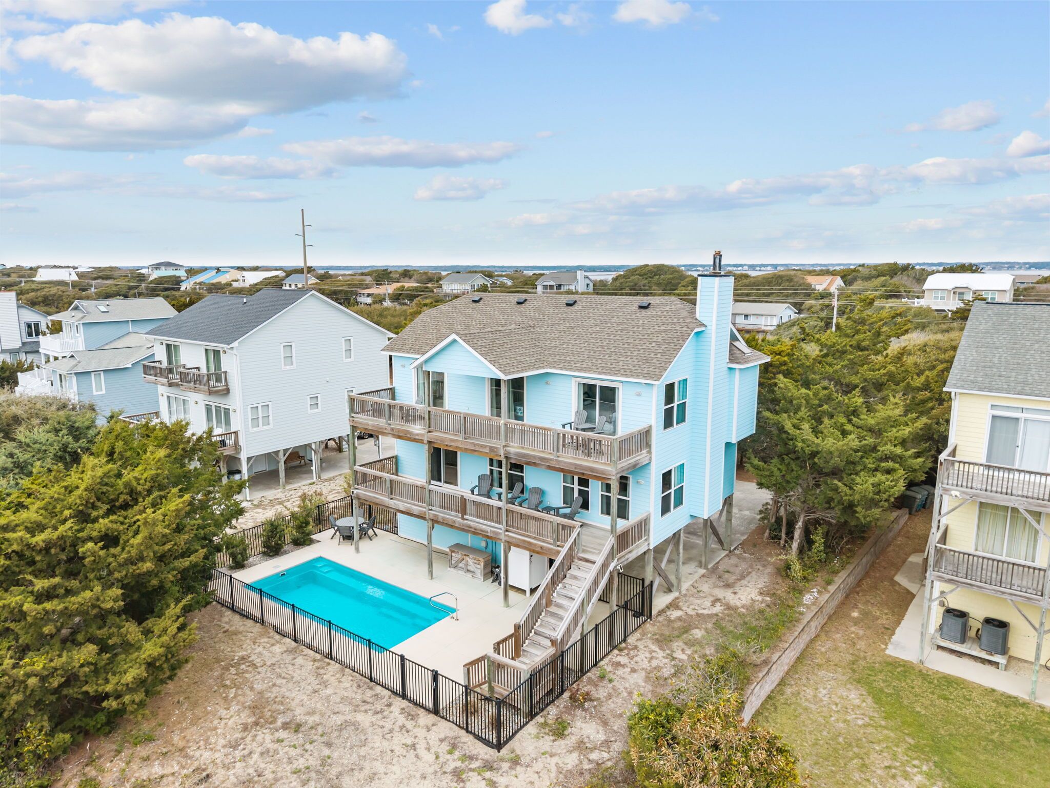 A two-story house with a balcony, a swimming pool, and a view of the surrounding neighborhood.