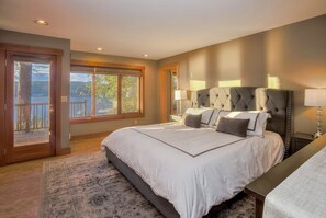 Ein Schlafzimmer mit einem großen Bett, Seeblick und einem Balkon.