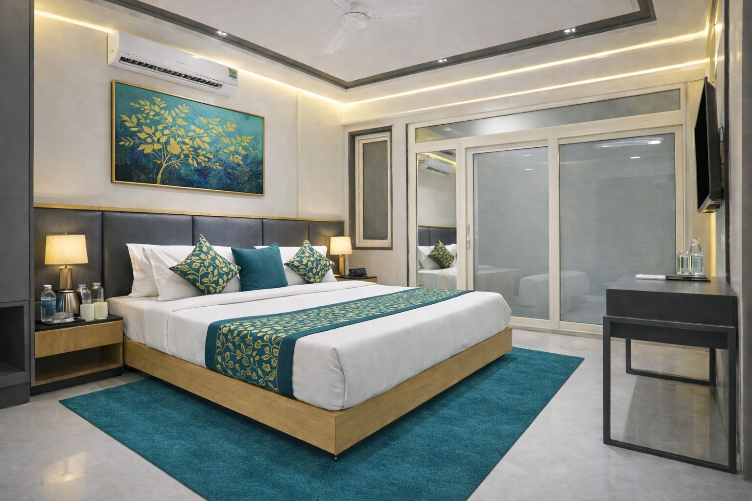 A modern hotel room with a large bed, bedside tables, a desk, and a sliding glass door leading to a balcony.