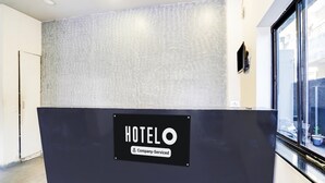 Un comptoir d’accueil d’hôtel avec un panneau indiquant qu’il est géré par l’entreprise.